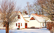 Bauernhaus und Neubau im Winter